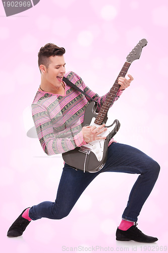 Image of  casual young man playing a guitar