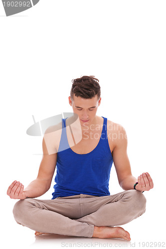 Image of  handsome man meditating in lotus position