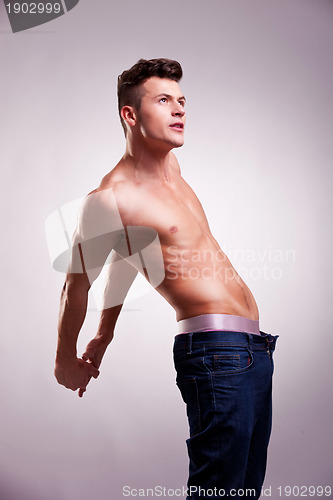 Image of muscular man with no shirt stretching 