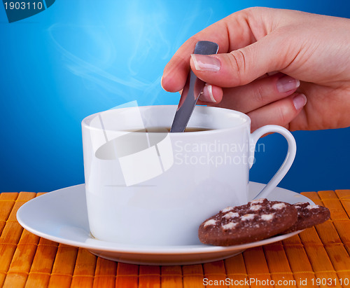 Image of woman stiring in a fresh cup of coffee