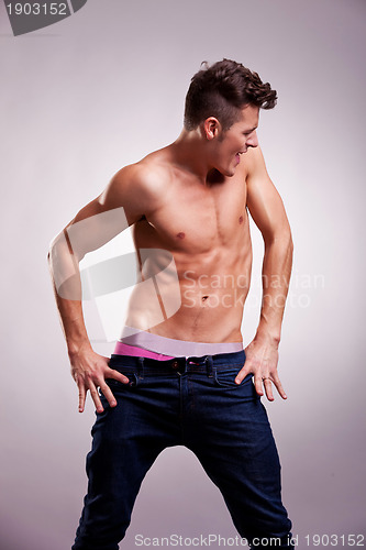 Image of excited muscular fashion model in a dance pose