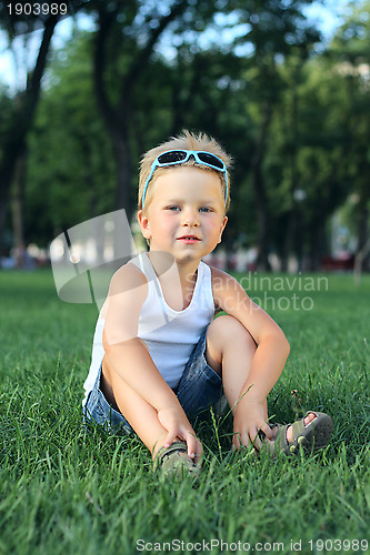Image of Little boy sitting in the park