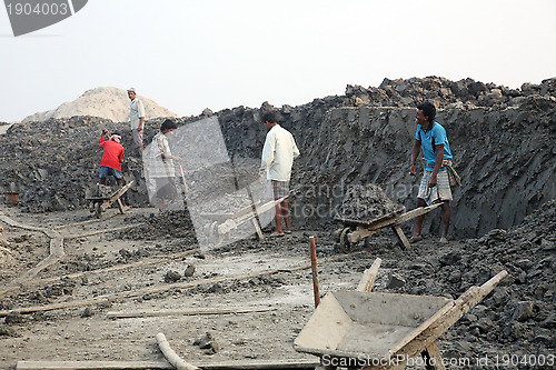 Image of Brick field. Laborers are carrying deposited soil for making raw brick. in Sarberia, West Bengal, India.