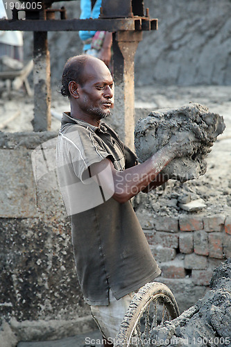 Image of Brick field. Laborers are carrying deposited soil for making raw brick. in Sarberia, West Bengal, India.