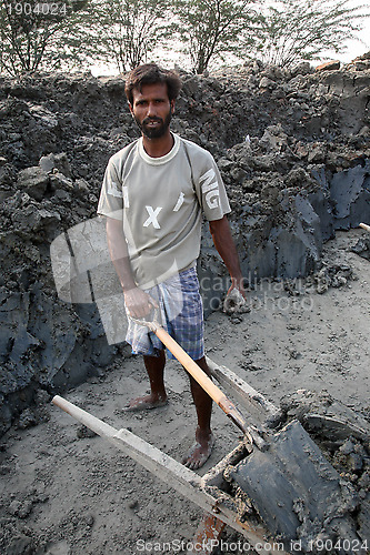 Image of Brick field. Laborers are carrying deposited soil for making raw brick. in Sarberia, West Bengal, India.