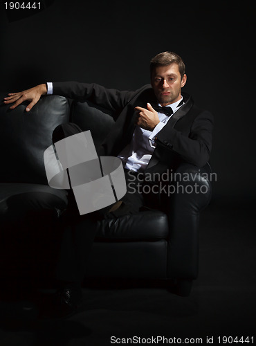Image of Handsome man in a tuxedo on couch