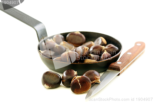 Image of Knife and the chestnuts in a pan.