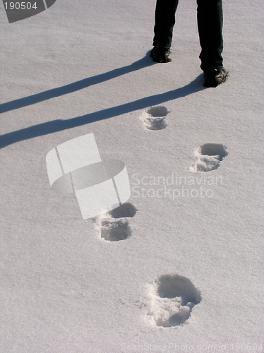 Image of Man legs and footprints on the snow