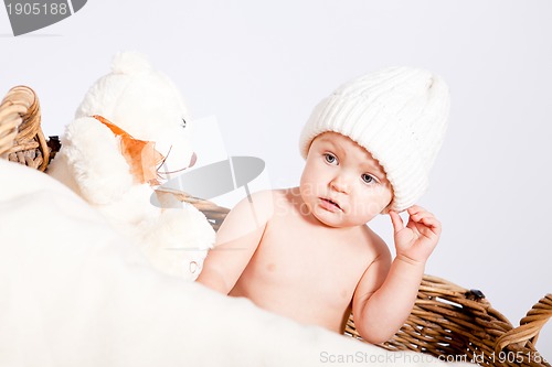 Image of cute little baby infant in basket with teddy 