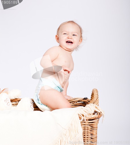 Image of cute little baby infant in basket with teddy 