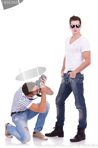 Image of young man wearing sunglasses being photographed 