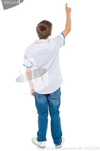 Image of Rear view of a school boy pointing upwards