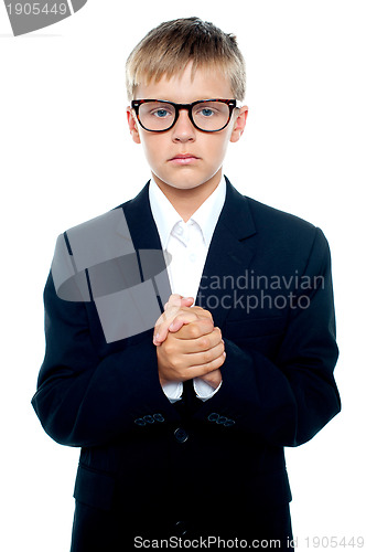 Image of Pensive looking boy posing with hands clasped