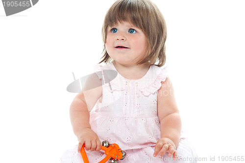 Image of Adorable blonde infant playing with a rattle