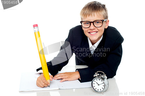 Image of Casual shot of a school kid finishing his assignment in time