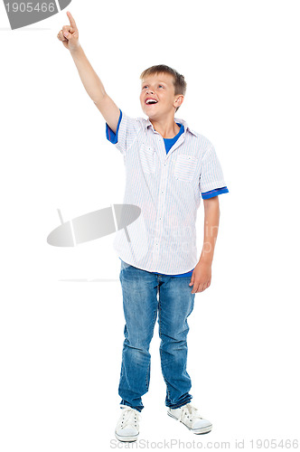 Image of Charming young boy pointing towards copyspace area