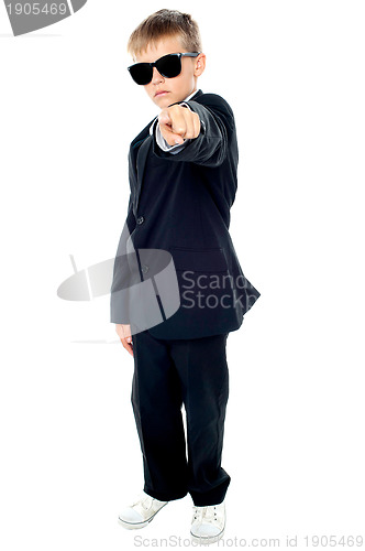 Image of Small boy in blue suit pointing at you