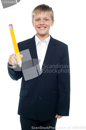 Image of Cheerful young boy holding giant sized yellow pencil