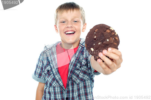 Image of Cheerful boy offering you a chocolate cookie