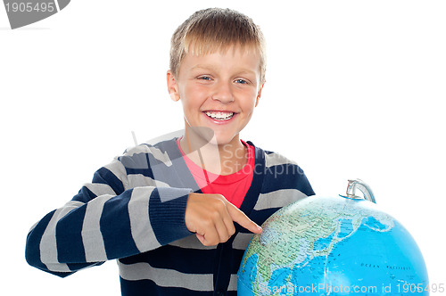 Image of Cute little boy pointing out a continent on the globe