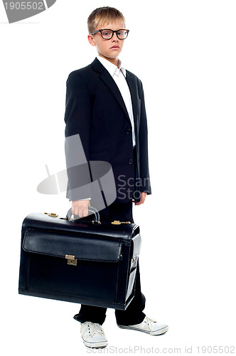 Image of Serious young business boy holding office briefcase