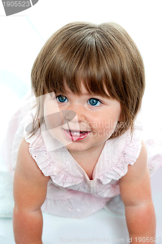 Image of Baby girl with milk teeth crawling on the ground
