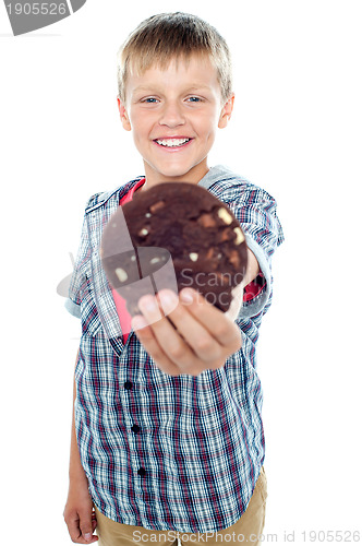 Image of Happy little young boy holding choco chip cookie