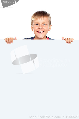 Image of Young boy hiding behind big whiteboard ad