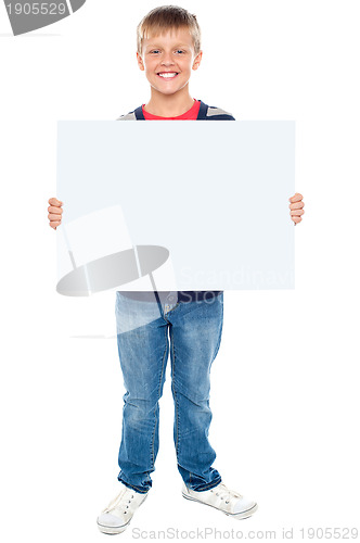 Image of Full length portrait of boy holding blank whiteboard
