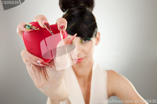 Image of woman holding heart in one hand