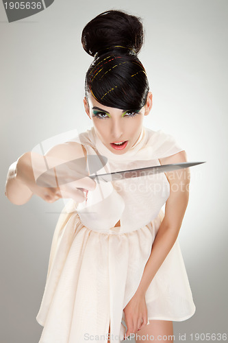 Image of woman in dress attacking with big kitchen knife