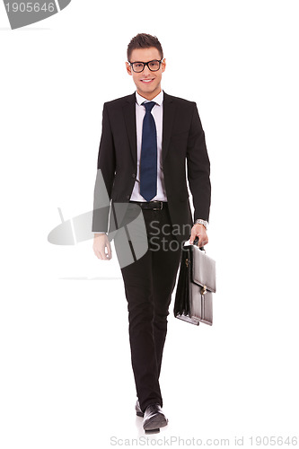 Image of young business man carrying a suitcase, walking