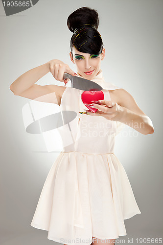 Image of woman cutting heart with knife