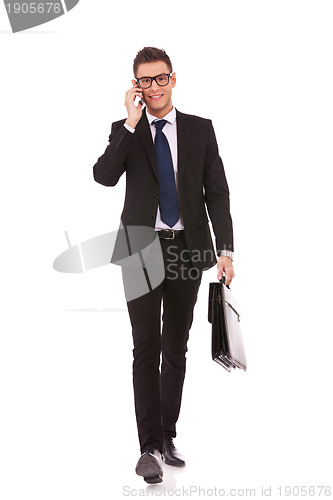 Image of business man walking and talking on phone