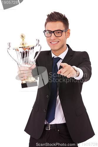 Image of  business man holding a trophy and pointing 