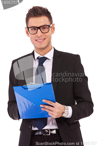 Image of business man wearing glasses is writing  on clipboard 