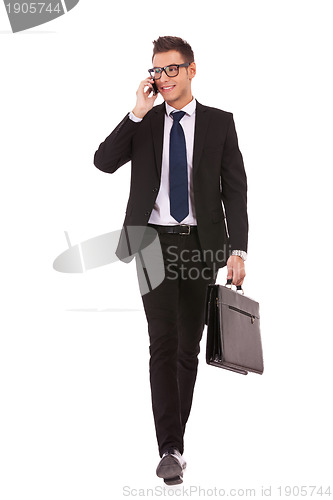 Image of business man walking and talking on phone