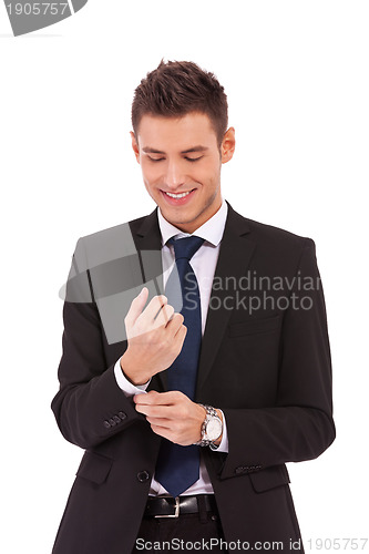 Image of smiling business man buttoning his sleeve