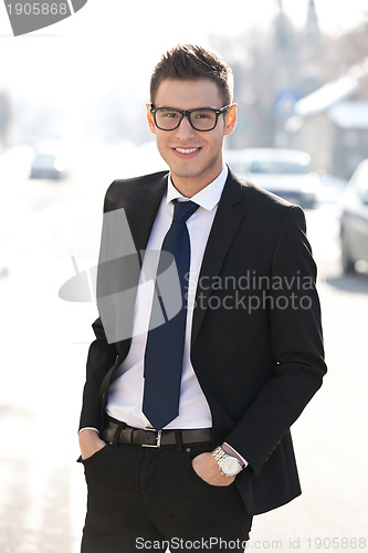 Image of  business man standing with hands in pockets