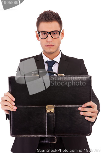 Image of serious business man offering a briefcase