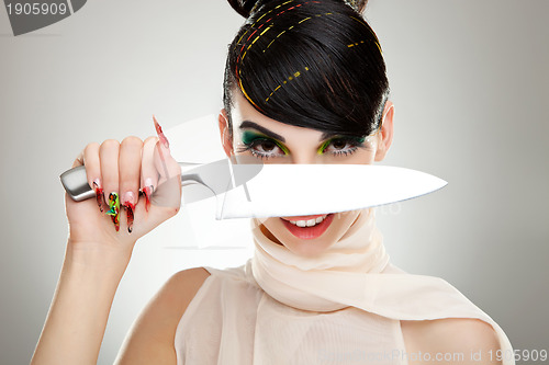 Image of woman with a knife over her face