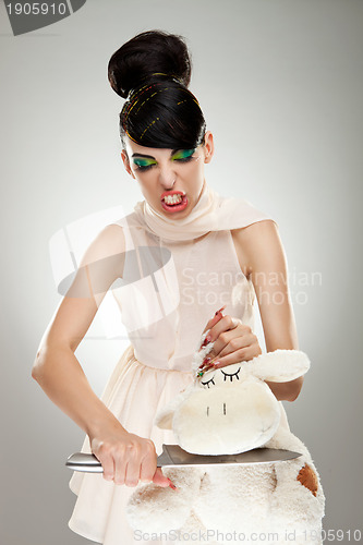 Image of woman cutting the neck of her teddy bear 