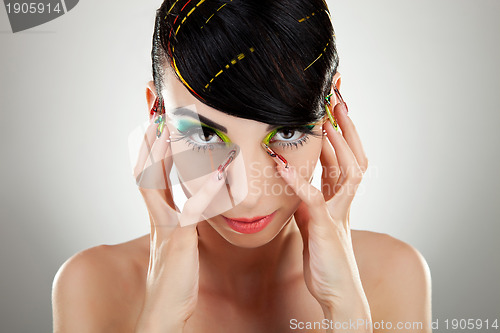 Image of Woman face with color makeup and manicure