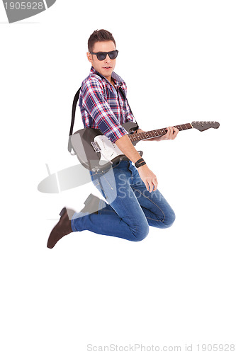Image of passionate guitarist jumps in the air 