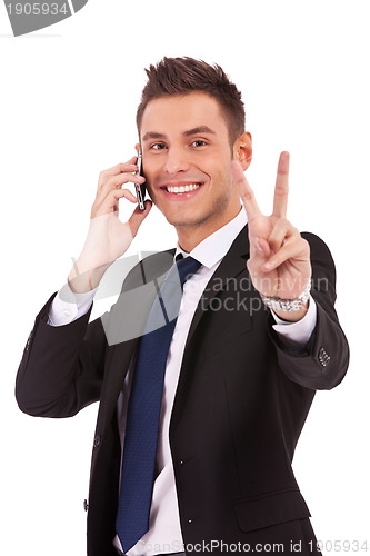 Image of business man making victory sign on phone