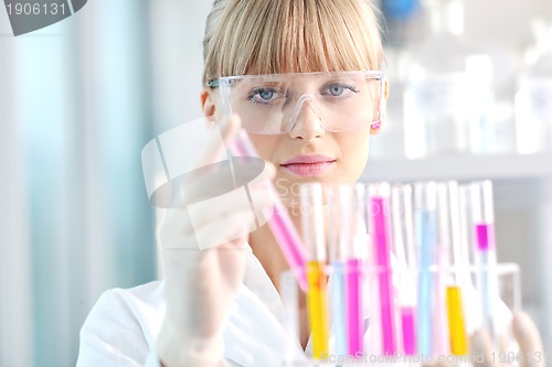 Image of female researcher holding up a test tube in lab