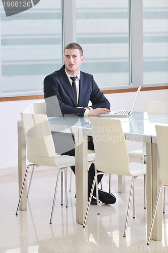 Image of young business man alone in conference room