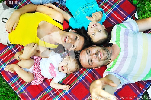 Image of happy young couple with their children have fun at park