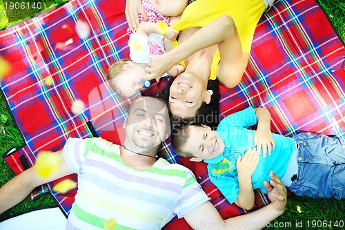 Image of happy young couple with their children have fun at park