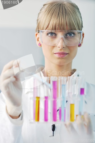 Image of female researcher holding up a test tube in lab